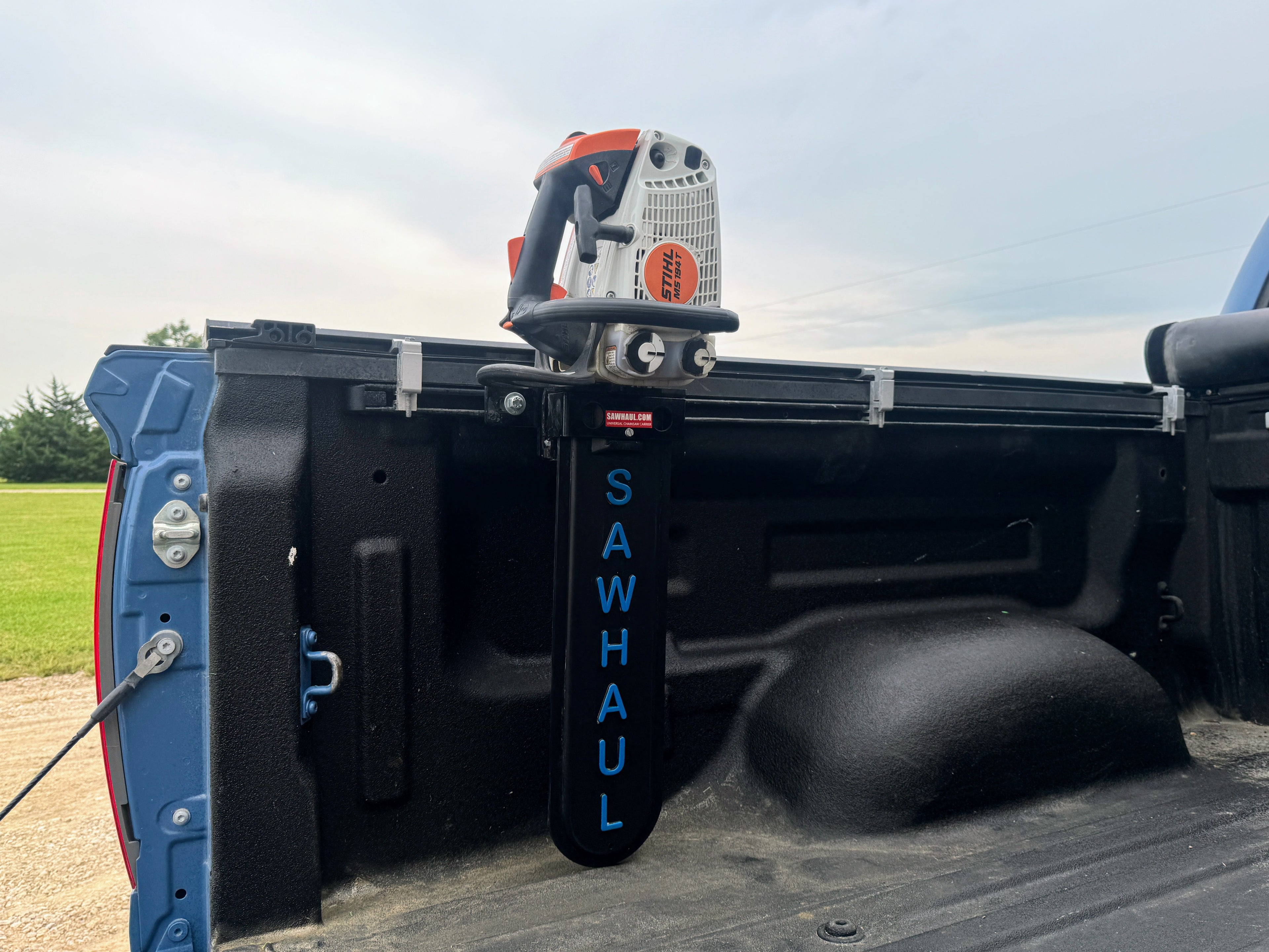 Sawhaul tool holder mounted on a truck bed with a power tool attached.