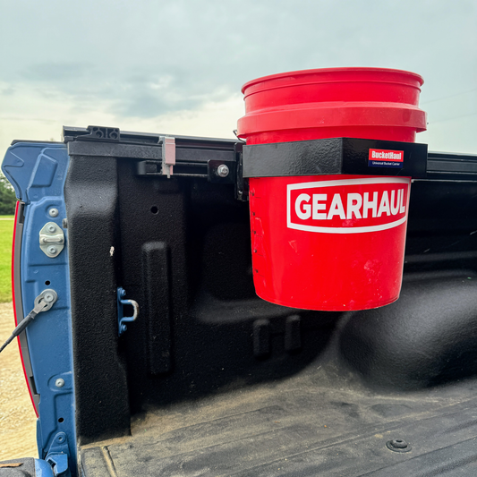 Red 'Gearhaul' bucket attached to a Toyota open tailgate