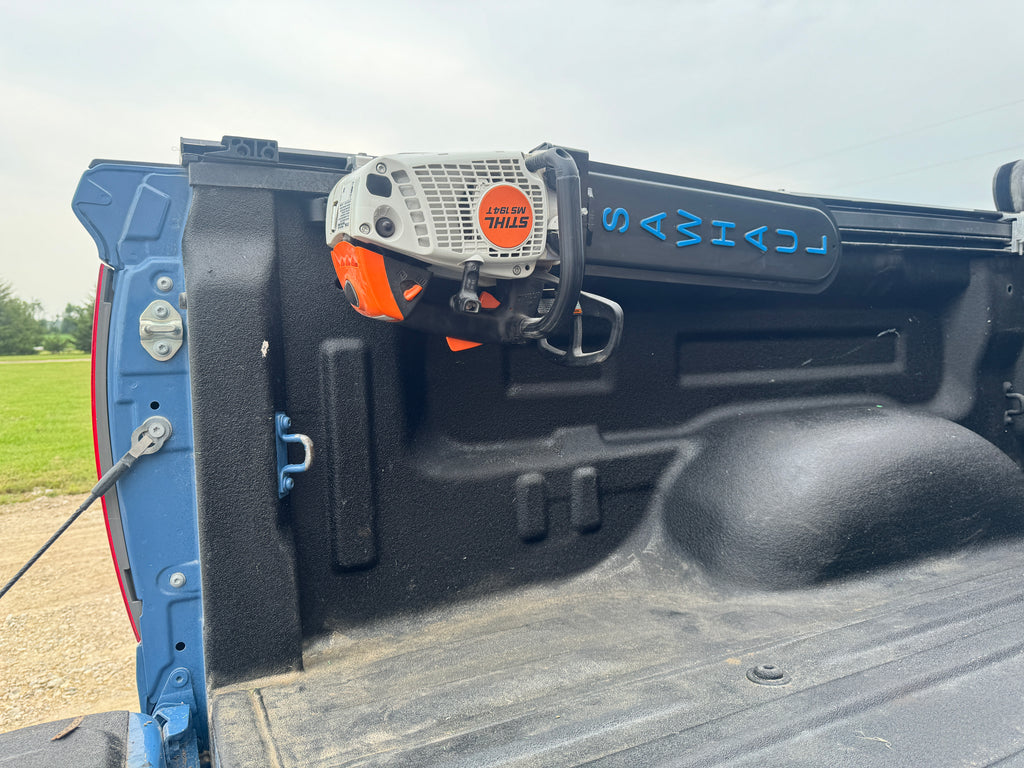 CHAINSAW IN A SAWHAUL ON THE BED OF A TOYOTA TRUCK